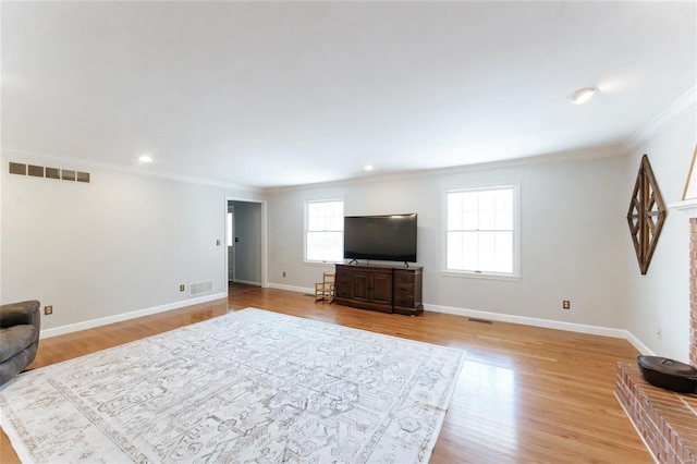 living room with ornamental molding, light wood-type flooring, baseboards, and recessed lighting