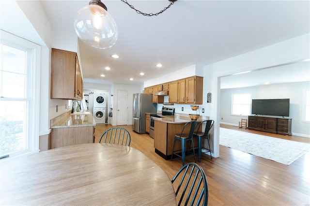 dining room with stacked washer and clothes dryer, recessed lighting, and light wood finished floors