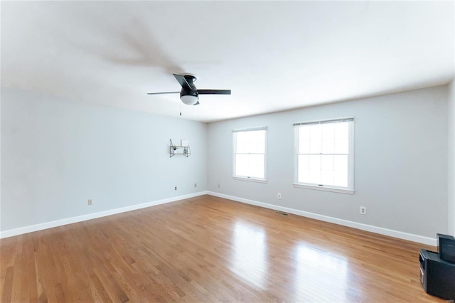 spare room featuring ceiling fan, baseboards, and wood finished floors