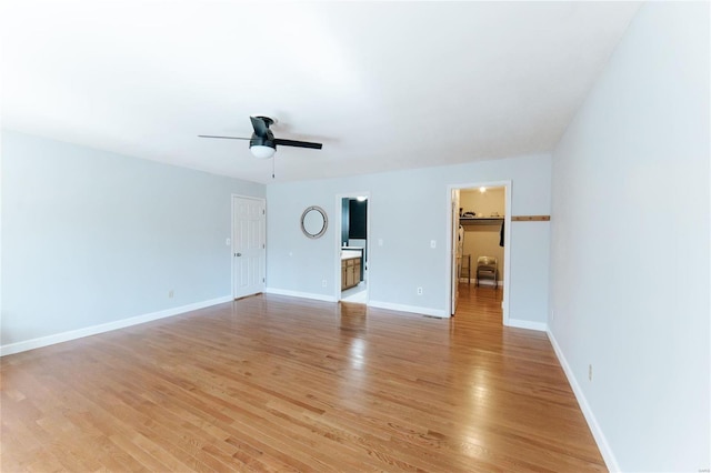 empty room featuring light wood-style floors, a ceiling fan, and baseboards