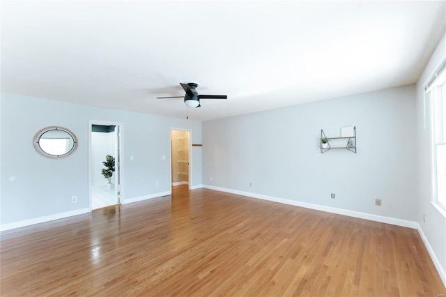 unfurnished living room with a ceiling fan, light wood finished floors, and baseboards