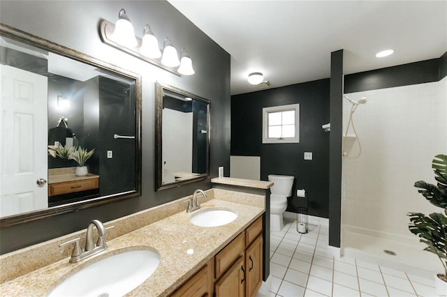 bathroom with tile patterned flooring, a tile shower, double vanity, toilet, and baseboards