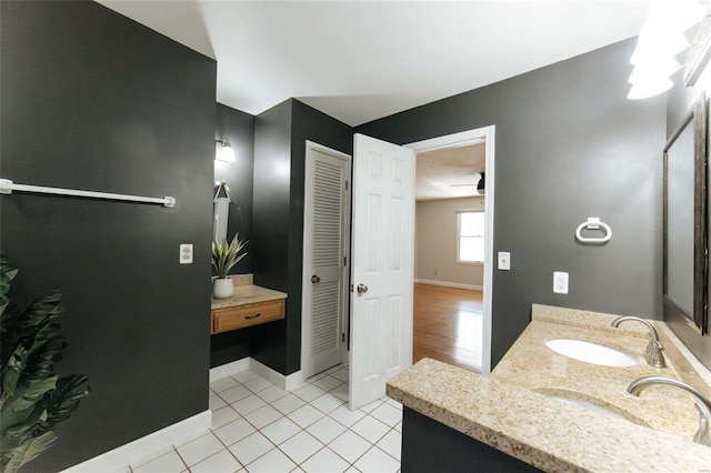 bathroom with double vanity, tile patterned floors, baseboards, and ceiling fan