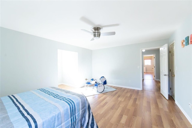 unfurnished bedroom with light wood-style flooring, baseboards, and a ceiling fan