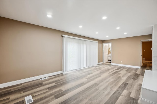 unfurnished living room with light wood-style flooring, recessed lighting, and baseboards
