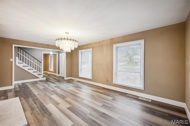 15 Chamblee Ln, Saint Louis, MO 63141 - unfurnished living room with stairway, baseboards, wood finished floors, and a chandelier