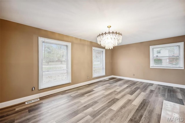 15 Chamblee Ln, Saint Louis, MO 63141 - spare room with plenty of natural light, a chandelier, wood finished floors, and baseboards