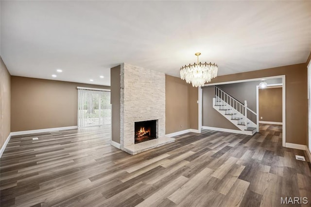 15 Chamblee Ln, Saint Louis, MO 63141 - unfurnished living room with stairs, wood finished floors, baseboards, a fireplace, and a chandelier