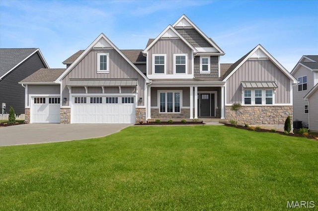 craftsman inspired home with board and batten siding, stone siding, a front lawn, and concrete driveway
