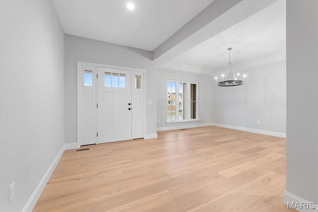 entrance foyer featuring a chandelier, light wood-style floors, and baseboards
