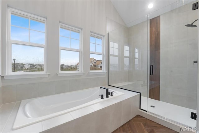 full bathroom with vaulted ceiling, a shower stall, and a garden tub