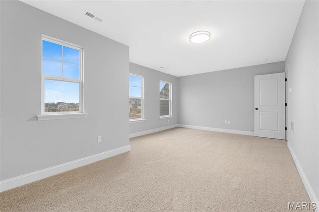 unfurnished room with light colored carpet and baseboards