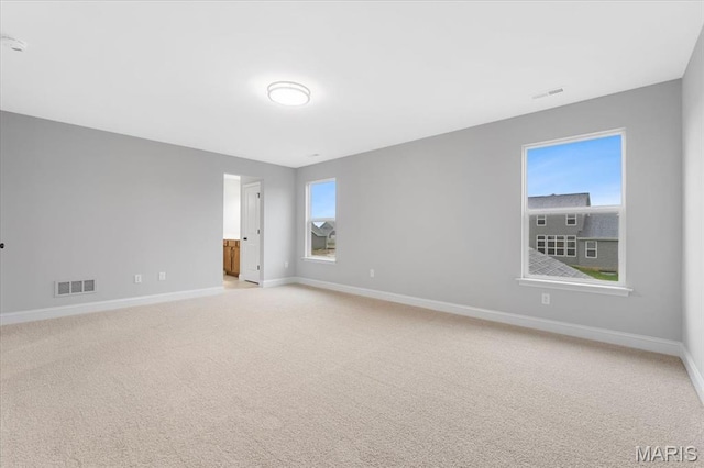 empty room with baseboards and light colored carpet
