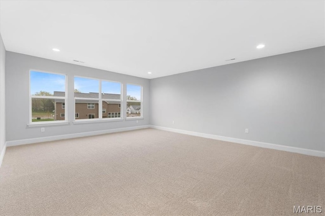 spare room featuring light colored carpet, baseboards, and recessed lighting