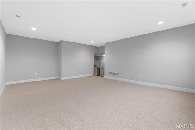 spare room featuring recessed lighting, light carpet, and baseboards