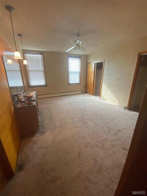 125 S 5th, Saint Charles, MO 63301 - carpeted spare room with ceiling fan, baseboard heating, and a textured ceiling