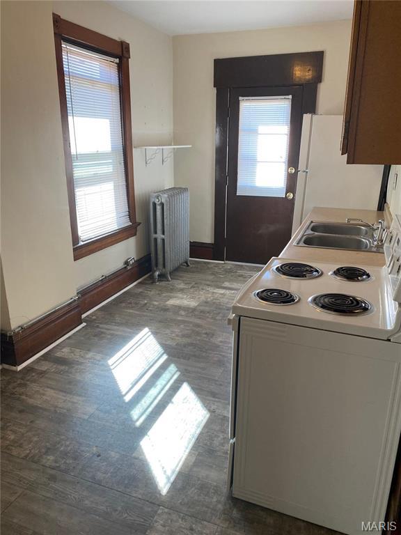 125 S 5th, Saint Charles, MO 63301 - kitchen featuring white appliances, radiator heating unit, dark wood-type flooring, and a sink