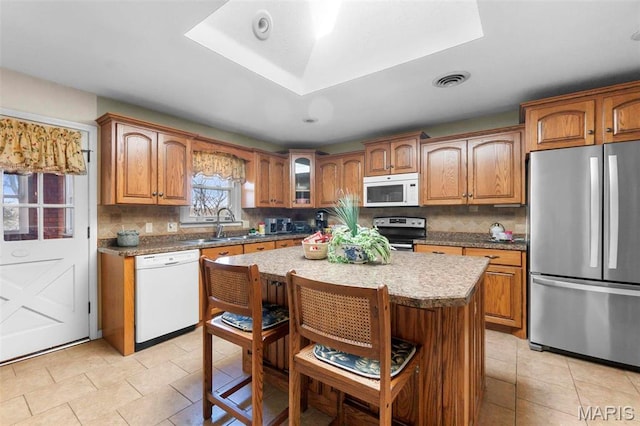 11 Schonhoff Cpe, Girardeau, MO 63703 - kitchen featuring stainless steel appliances, a sink, tasteful backsplash, light tile patterned floors, and brown cabinets