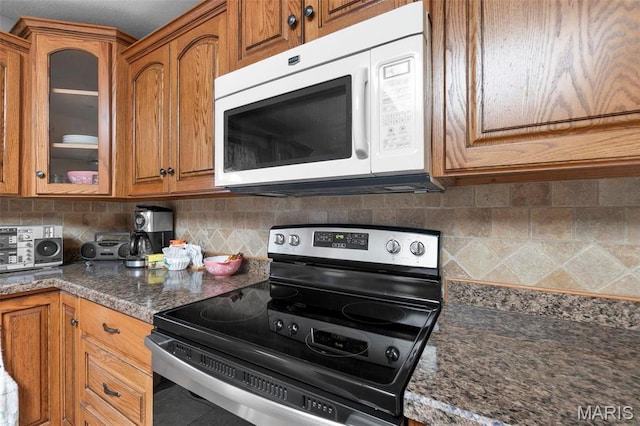 11 Schonhoff Cpe, Girardeau, MO 63703 - kitchen with stainless steel electric range oven, white microwave, brown cabinets, glass insert cabinets, and backsplash