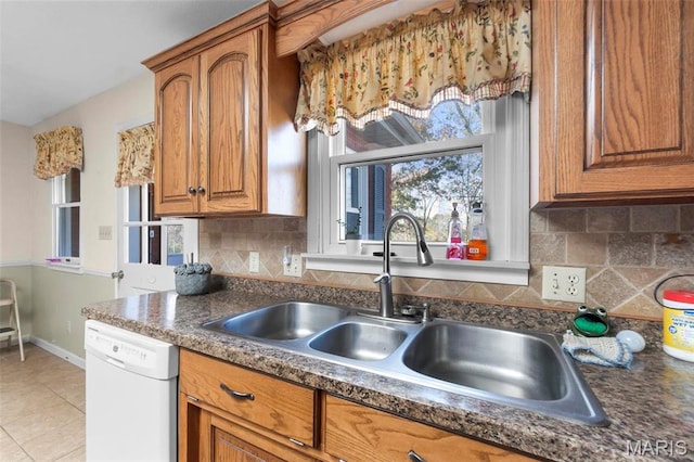 11 Schonhoff Cpe, Girardeau, MO 63703 - kitchen with white dishwasher, brown cabinetry, a sink, and dark countertops