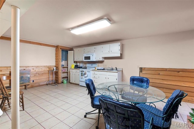 11 Schonhoff Cpe, Girardeau, MO 63703 - kitchen featuring white appliances, light tile patterned floors, a sink, white cabinets, and wood walls