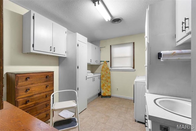 11 Schonhoff Cpe, Girardeau, MO 63703 - laundry room featuring a textured ceiling, washer / dryer, and baseboards