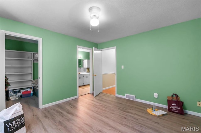 11 Schonhoff Cpe, Girardeau, MO 63703 - unfurnished bedroom featuring wood finished floors, a spacious closet, baseboards, ensuite bath, and a closet