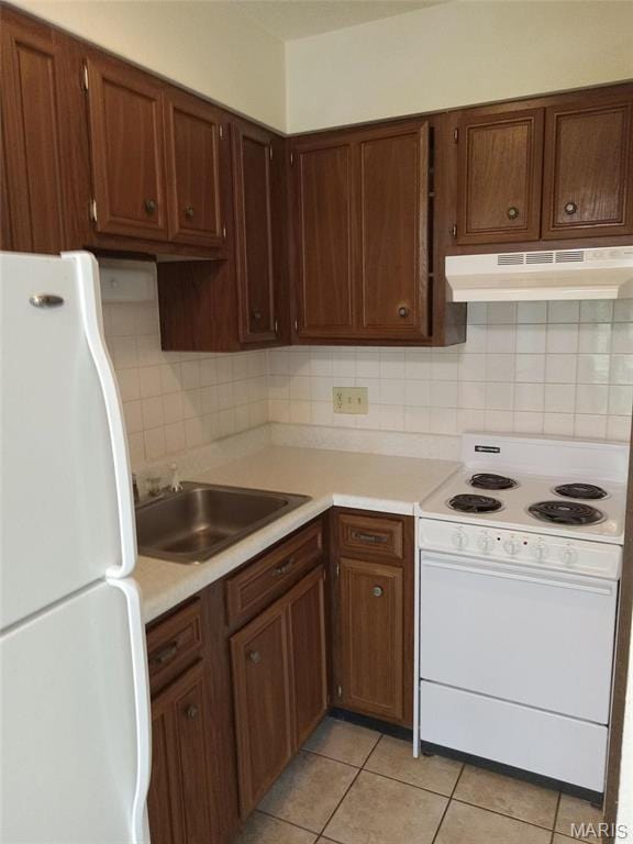 753 Rozier St, Saint Genevieve, MO 63670 - kitchen with white appliances, under cabinet range hood, a sink, and light countertops