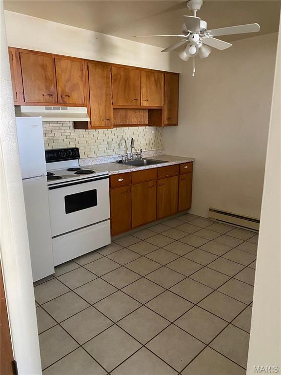 753 Rozier St, Saint Genevieve, MO 63670 - kitchen featuring white appliances, under cabinet range hood, baseboard heating, a sink, and tasteful backsplash