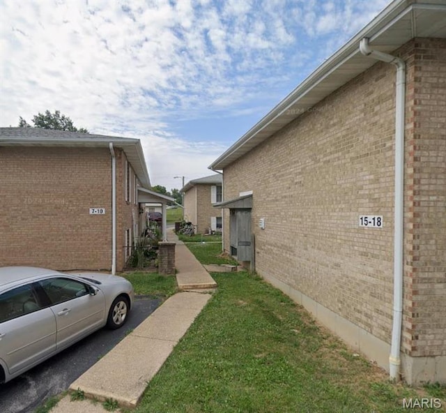 753 Rozier St, Saint Genevieve, MO 63670 - view of side of property featuring brick siding and a lawn