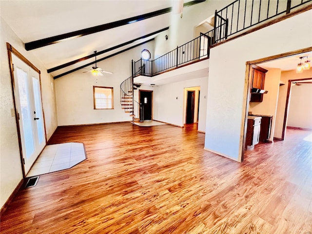 16144 Horse Shoe Dr, Houston, MO 65483 - unfurnished living room featuring wood finished floors, stairs, high vaulted ceiling, beam ceiling, and a ceiling fan