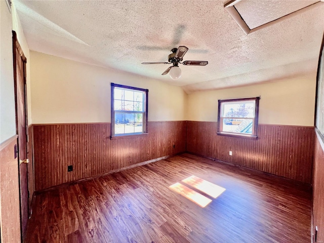 16144 Horse Shoe Dr, Houston, MO 65483 - empty room featuring a wainscoted wall, wood finished floors, a textured ceiling, plenty of natural light, and ceiling fan