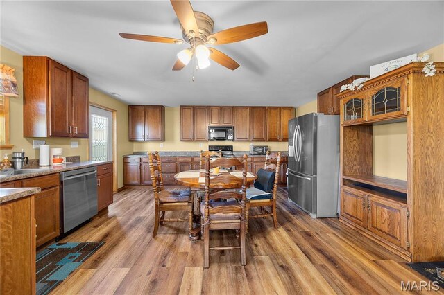 9136 Beach Dr, French Village, MO 63036 - kitchen with appliances with stainless steel finishes, wood finished floors, and brown cabinetry