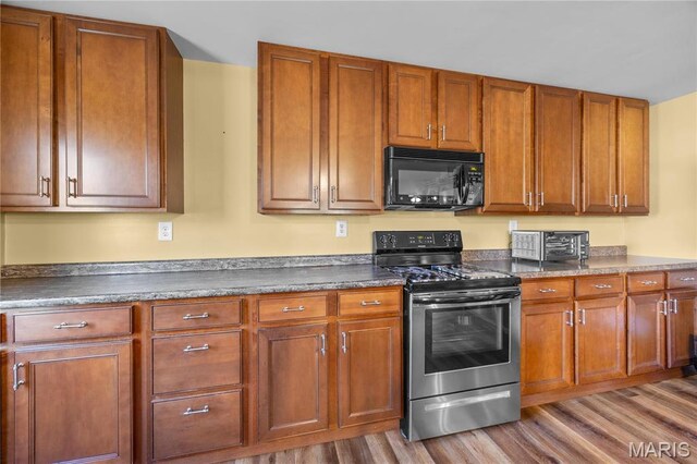 9136 Beach Dr, French Village, MO 63036 - kitchen featuring black microwave, electric stove, wood finished floors, and dark countertops