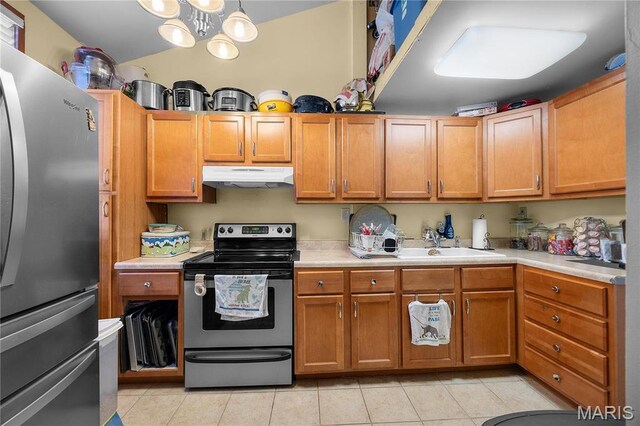 9136 Beach Dr, French Village, MO 63036 - kitchen featuring appliances with stainless steel finishes, under cabinet range hood, a sink, light countertops, and light tile patterned floors