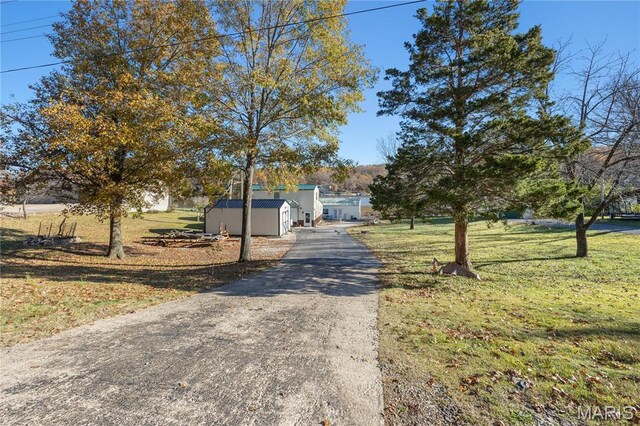 9136 Beach Dr, French Village, MO 63036 - view of front of property with a storage unit, asphalt driveway, an outdoor structure, and a front yard