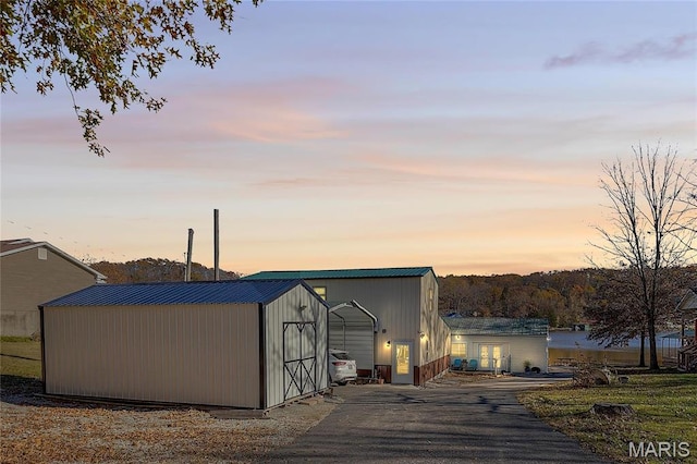 9136 Beach Dr, French Village, MO 63036 - outdoor structure at dusk featuring an outdoor structure, asphalt driveway, and a storage unit