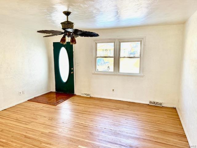 foyer with light wood-style flooring, baseboards, and ceiling fan