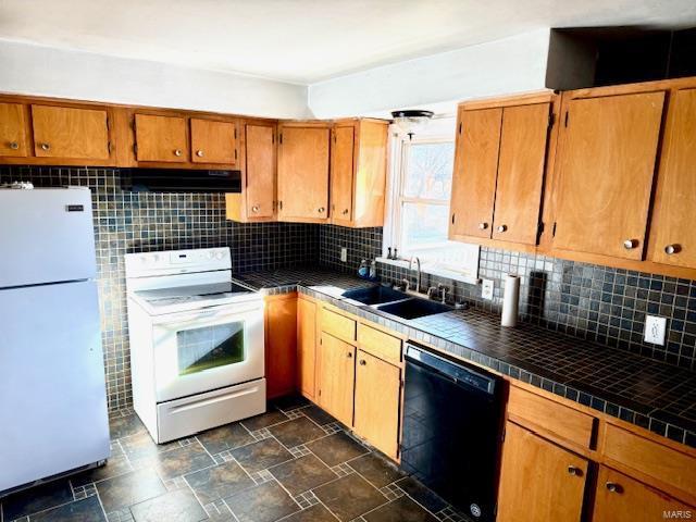 kitchen featuring white appliances, tile countertops, a sink, and under cabinet range hood