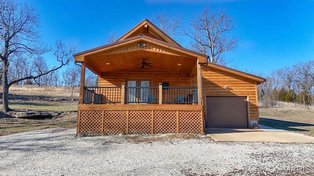 9454 Little Indian Creek Rd, Lonedell, MO 63060 - view of front facade featuring a garage, concrete driveway, ceiling fan, covered porch, and log veneer siding