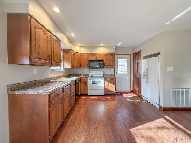 9454 Little Indian Creek Rd, Lonedell, MO 63060 - kitchen featuring range with electric stovetop, white fridge with ice dispenser, black microwave, dark wood-type flooring, and brown cabinets