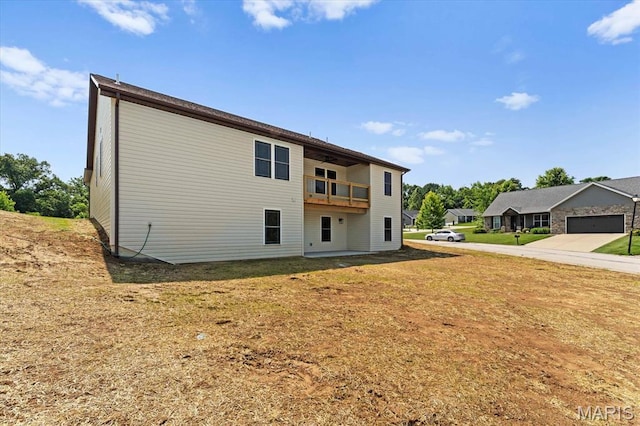 955 Half Moon Ln, Caseyville, IL 62232 - back of house featuring a balcony, driveway, and a lawn