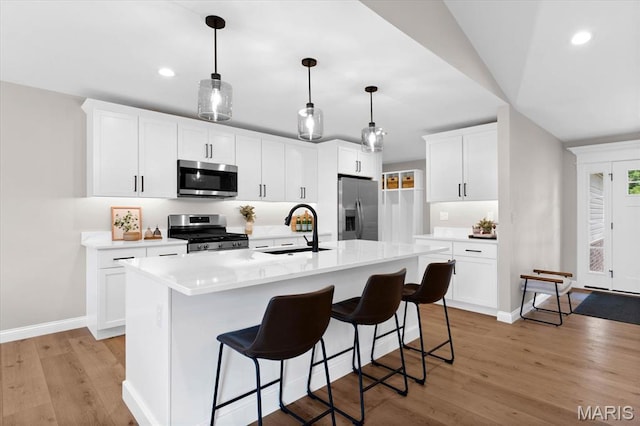 955 Half Moon Ln, Caseyville, IL 62232 - kitchen featuring stainless steel appliances, light wood-type flooring, light countertops, a breakfast bar, and recessed lighting