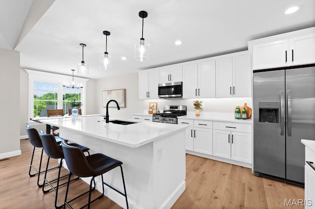 955 Half Moon Ln, Caseyville, IL 62232 - kitchen featuring stainless steel appliances, recessed lighting, light wood-style flooring, an island with sink, and white cabinets