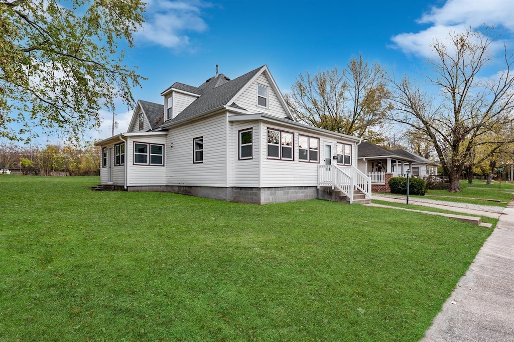 view of side of home with a yard and a shingled roof