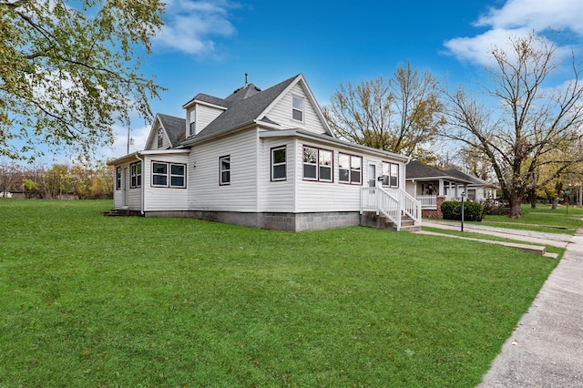 view of side of home with a yard and a shingled roof