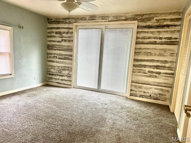 201 County Highway 331, Benton, MO 63736 - carpeted empty room featuring wood walls, a ceiling fan, and baseboards