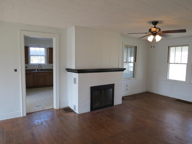 204 E Wayne St, Ironton, MO 63650 - unfurnished living room with wood finished floors, a sink, ceiling fan, and a fireplace