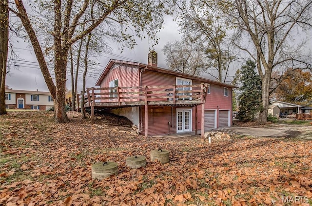 23388 Glenda Ave, Jerseyville, IL 62052 - rear view of property featuring a chimney, a garage, a deck, asphalt driveway, and french doors