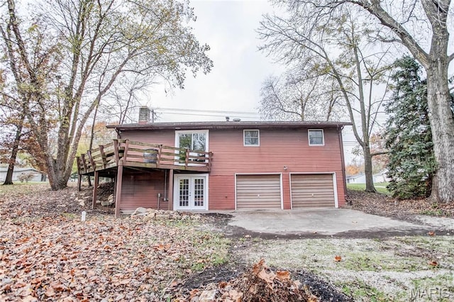 23388 Glenda Ave, Jerseyville, IL 62052 - back of house featuring a chimney, an attached garage, a wooden deck, french doors, and driveway
